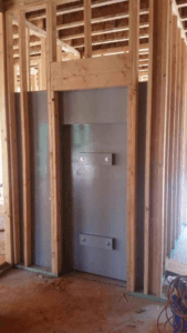 Pre-fabricated framed safe room with a secure door, ideal for homes
