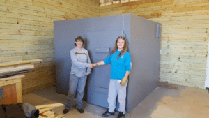 Two people shaking hands in front of a safe room